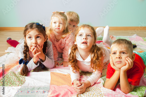 Close view of five kids laying on a floor