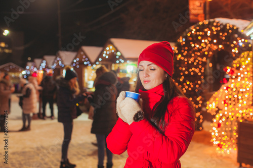 Happy attractive woman dreaming with cup of tea, Christmas market