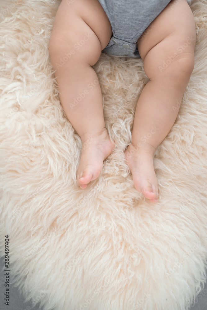 Baby's foot on sofa in the room, close up Baby's foot on sofa in the room, close up