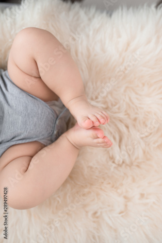 Baby's foot on sofa in the room, close up