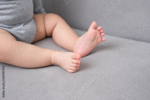 Baby's foot on sofa in the room, close up