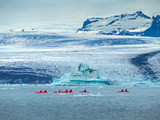 A group of friends in red kayaks near the Jökulsárlón glacier lagoon.