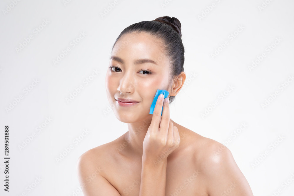 Beautiful Attractive Asian woman using Facial oil clean film to removal oily on face for face fresh skin feeling so fresh and clean,Beauty Concept,Isolated on grey background Beautiful Attractive Asian woman using Facial oil clean film to removal oily on face for face fresh skin feeling so fresh and clean,Beauty Concept,Isolated on grey background