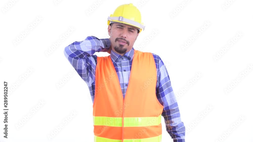 Stressed bearded Persian man construction worker having neck pain Stressed bearded Persian man construction worker having neck pain
