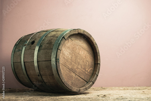 Beautiful wooden barrel on a old oak table and red wall background. photo