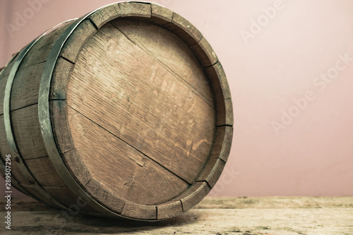 Beautiful wooden barrel on a old oak table and red wall background. photo