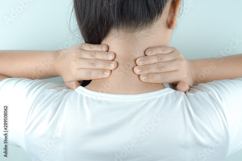 Closeup woman neck and shoulder feeling exhausted and suffering from neck and shoulder pain and injury on white background. Health care and medical concept.