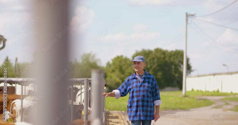 Farmer gesturing while writing on clipboard against barn Farmer gesturing while writing on clipboard against barn