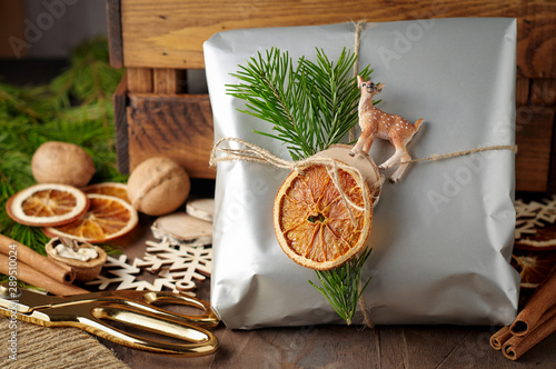 Obraz na płótnie Packaging christmas present handmade gift boxes decorated with silver paper with dried orange slices w salonie