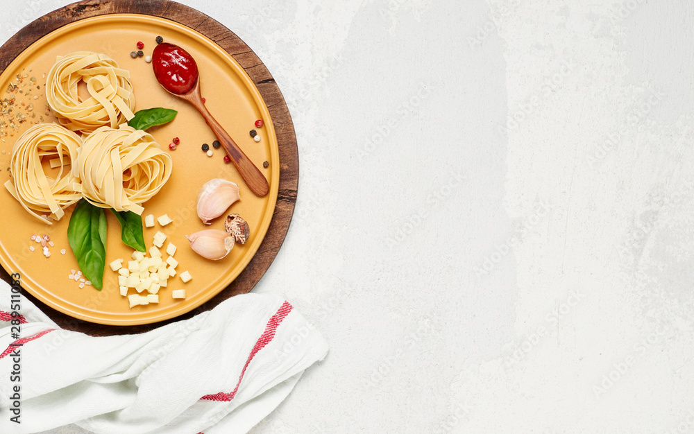 Ingredient for simple italian dinner on yellow plate. Fettuccine, fresh basil, tomato souce and mozzarella cheese