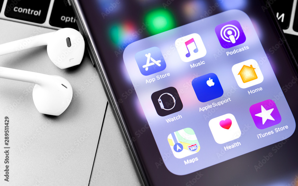 Macbook and iPhone with Earpods headphones. Apple Services