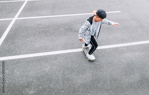 Teenager skateboarder boy with a skateboard on asphalt playground doing tricks. Youth generation Freetime spending concept image. © Soloviova Liudmyla