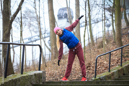 Woman wearing sportswear exercising outside during autumn