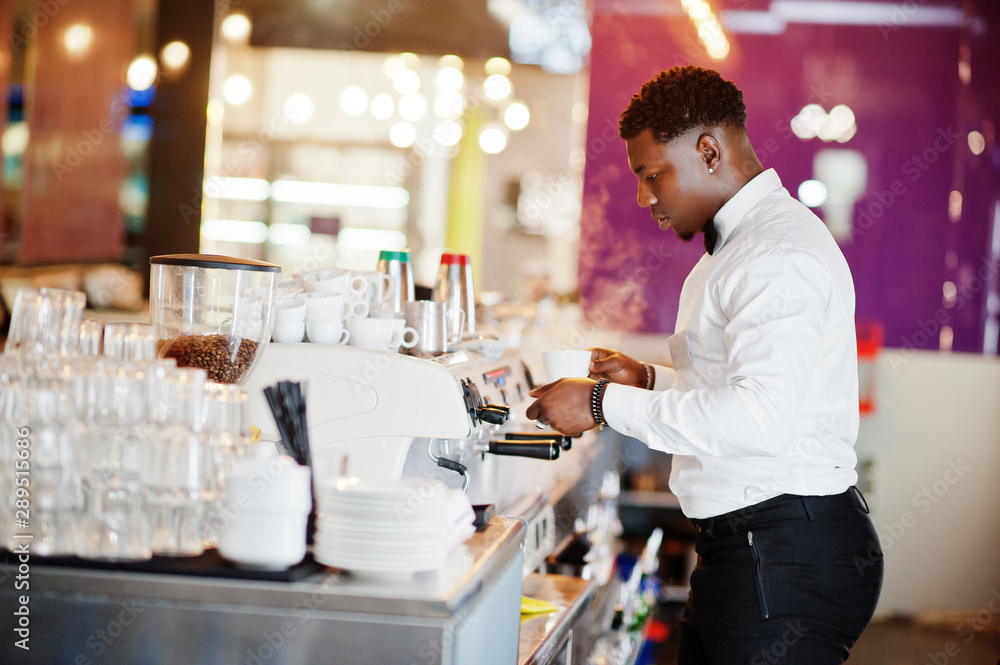 African american bartender barista at bar preparing coffee.