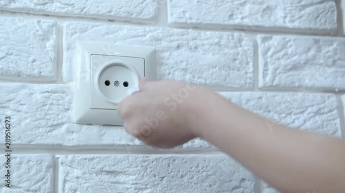 Child and electricity. The child pulls out the childproof protection from the socket.