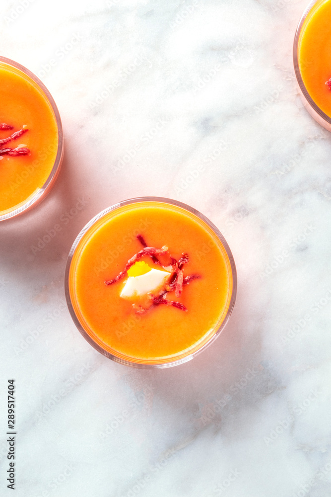 Salmorejo, typical Spanish cold tomato and bread soup, in glasses on a marble background, top shot with a place for text Salmorejo, typical Spanish cold tomato and bread soup, in glasses on a marble background, top shot with a place for text