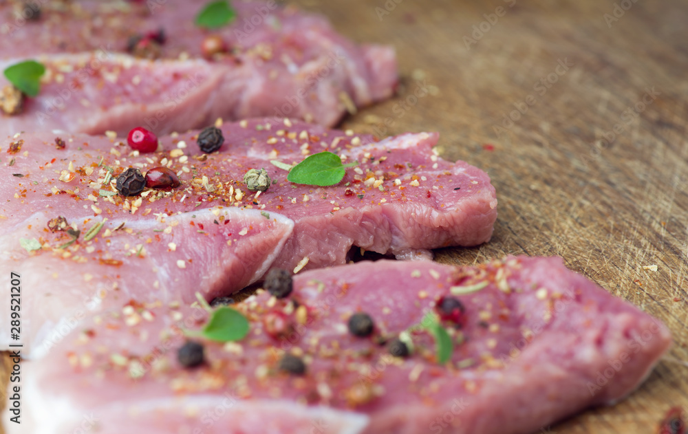 Steaks sprinkled with spices and herbs. Juicy steaks for a barbecue close up. Steaks sprinkled with spices and herbs. Juicy steaks for a barbecue close up.