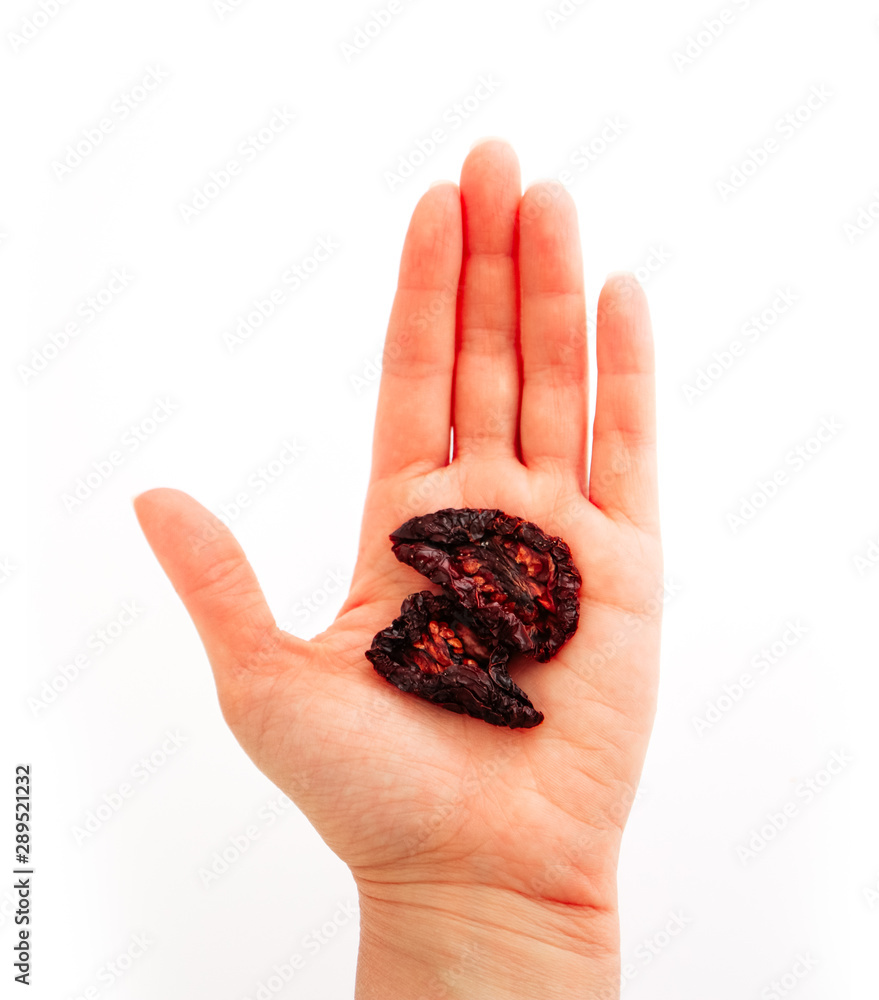 Hand holding a dried tomato, isolated on white background. Hand holding a dried tomato, isolated on white background.