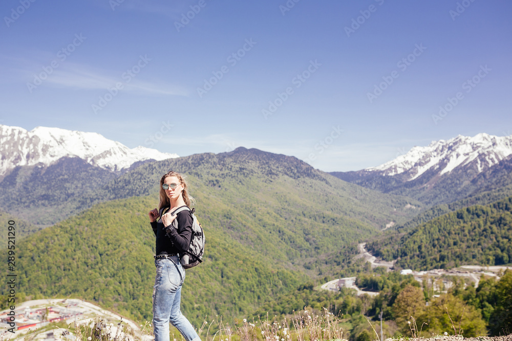 Naklejka premium Portrait of a beautiful young girl lover and protector of the environment and trekking goes to picturesque places in the mountains. Concept of Unity with nature, ecotourism
