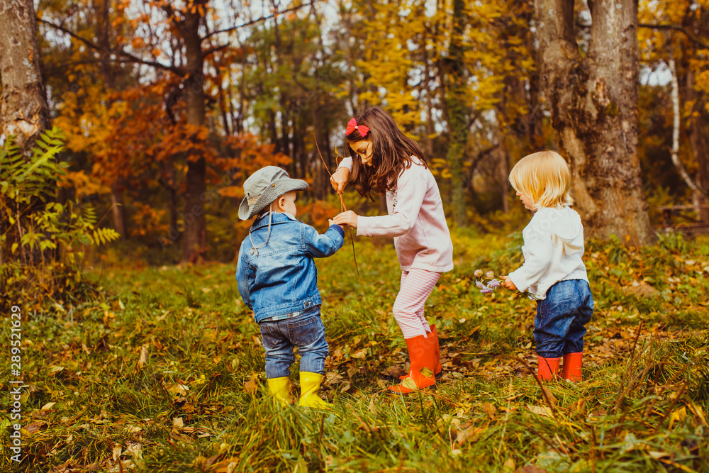 Fototapeta premium Little children playing in the park in autumn