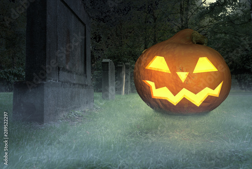 scary halloween pumpkin lies in a foggy cemetery