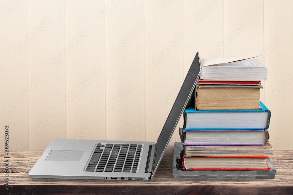 Stack of books with laptop on table Stack of books with laptop on table