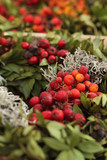 Bunter, natürlicher Beerenkranz mit grünen Blättern und roten Beeren, als Weihnachtsdekoration.