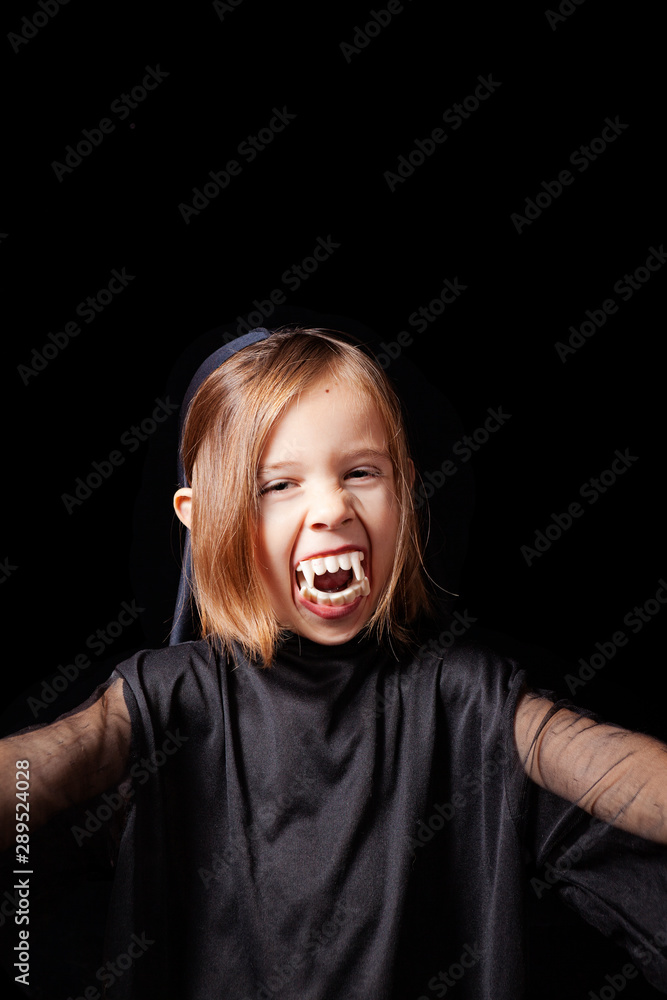 Divertido retrato de estudio de una niña de 5 años con un disfraz de halloween. Fondo negro Divertido retrato de estudio de una niña de 5 años con un disfraz de halloween. Fondo negro
