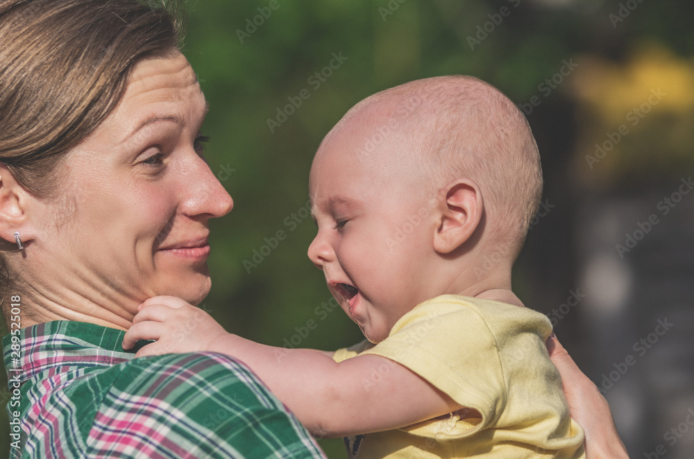 Close-up of a young mother holding a small baby in her arms Close-up of a young mother holding a small baby in her arms