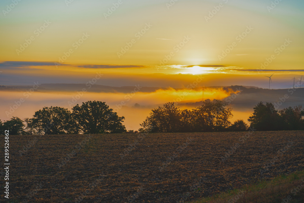 Sonnenaufgang über einer Nebel verhangenen Hügel Landschaft