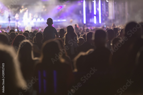 Silhouettes of concert crowd in front of stage lights. Fans during a life concert