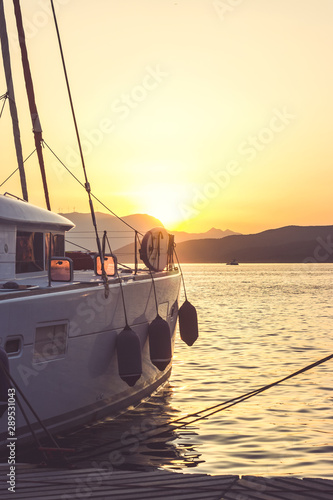 White yacht docked in sea port at beautiful sunset; summertime background with copy space