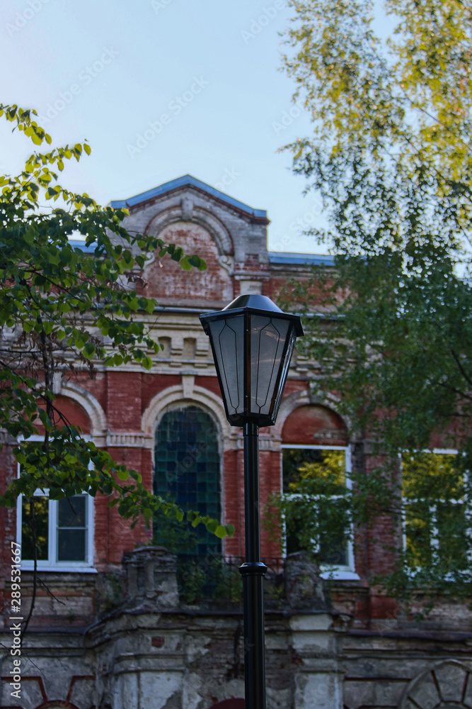 Obraz premium Beautiful lantern in the Park on the background of the historic building Karjak school
