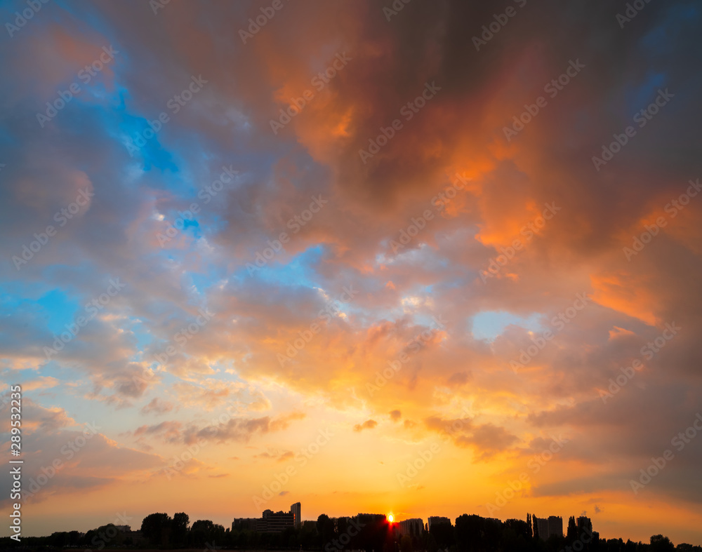 Cityscape silhouette at sunset under a majestic sky with sun setting behind the buildings and plenty of copy space Cityscape silhouette at sunset under a majestic sky with sun setting behind the buildings and plenty of copy space