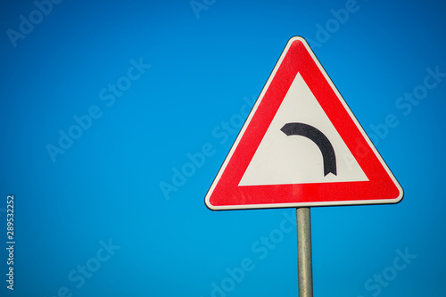 dangerous road sign isolated on blue sky