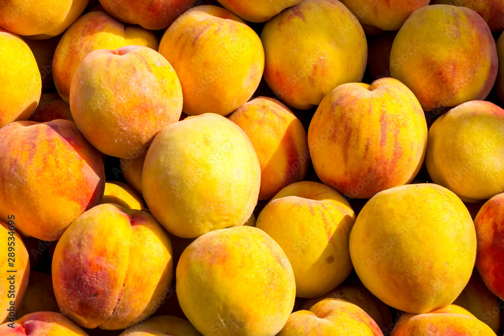 Peach fruit close-up. Texture background of sweet yellow ripe peaches. Fruit Peaches Food Image