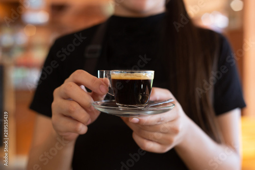 Hot espresso coffee in the woman's hand or the office staff during the morning and lunch break.