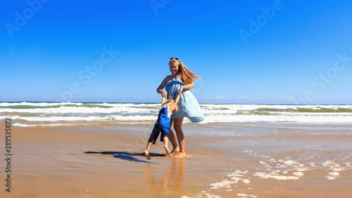 Mother and daughter are spinning on the beach at sunny day.