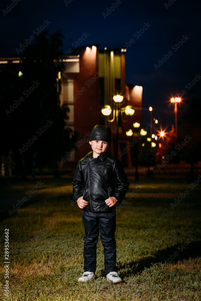 five-year-old stylish boy in a black leather jacket and leather pants on  the background of the city at night Stock Photo | Adobe Stock