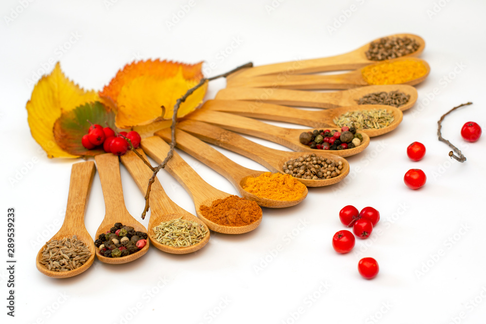 Fragrant dry spices in wooden spoons on white background. Pattern. Fragrant dry spices in wooden spoons on white background. Pattern.