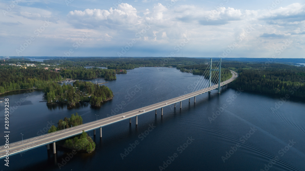 Aerial view of blue lakes, green forests and bridge.  Sunny summer day in rural Finland. Drone photography from the air.