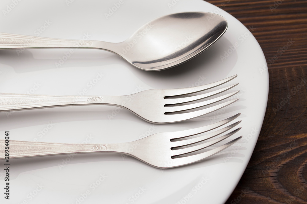Fork And spoon on Plate On wood table . Dishes and cutlery. Fork And spoon on Plate On wood table . Dishes and cutlery.