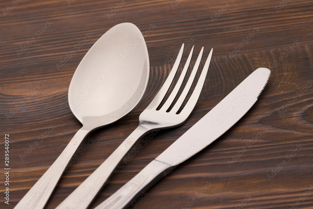 Cutlery Set. Spoon, Fork, Knife on a dark wood background. close up Cutlery Set. Spoon, Fork, Knife on a dark wood background. close up