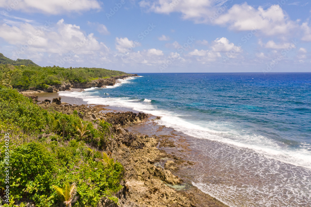 The rocky coast of a tropical island. Siargao, Philippines. Seascape with palm trees in sunny weather, aerial view. The rocky coast of a tropical island. Siargao, Philippines. Seascape with palm trees in sunny weather, aerial view.