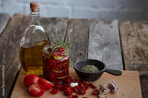 Fotografija Sun-dried tomatoes with Provencal herbs, garlic and olive oil on a rustic wooden