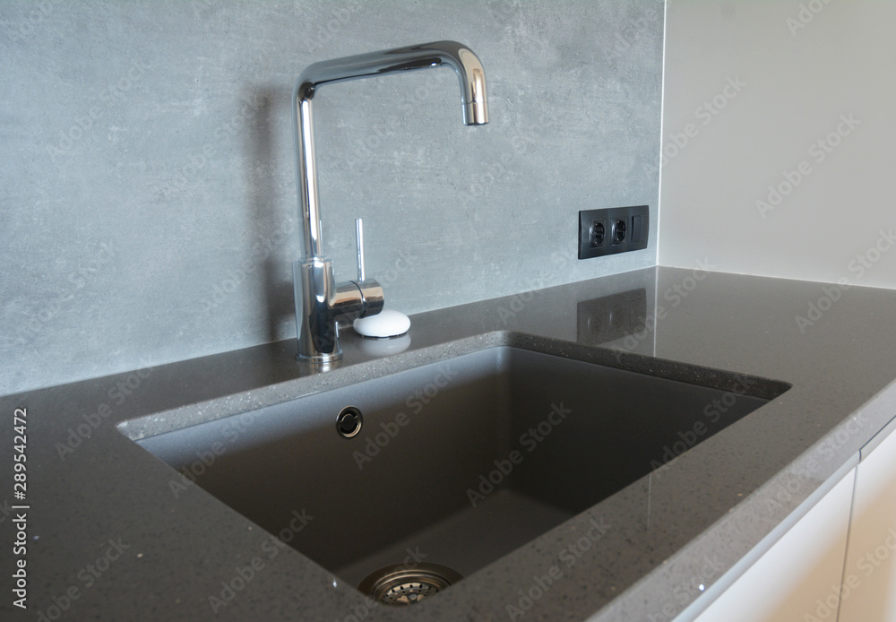 Fototapeta premium Modern kitchen chrome faucet and ceramic kitchen sink.