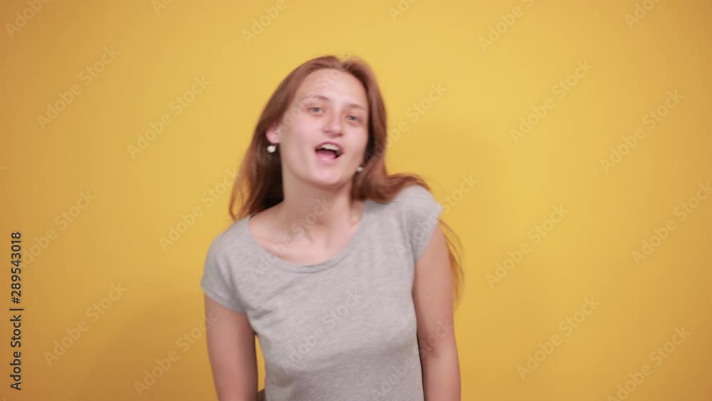 brunette girl in gray t-shirt over isolated orange background shows emotions brunette girl in gray t-shirt over isolated orange background shows emotions