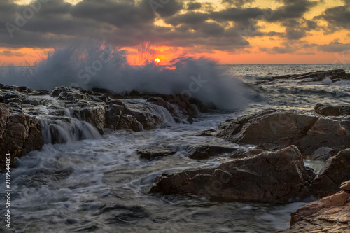 Beutiful sunrise seascape with rocky beach and crashing waves on cape Akin near Chernomorets, Bulgaria.