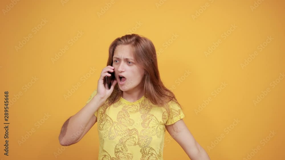 brunette girl in yellow t-shirt over isolated orange background shows emotions brunette girl in yellow t-shirt over isolated orange background shows emotions