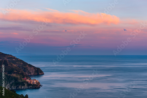 The fishing village of Manarola in Cinque Terre, Italy, at sunset with the Mediterranean sea as background